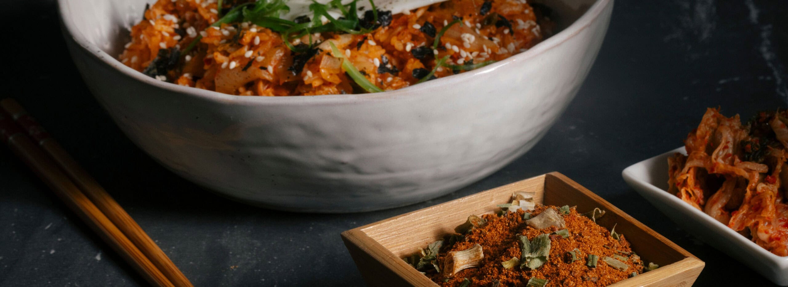 Asian flavors showcased for spices and seasonings with blends in bowls next to a dish of food.