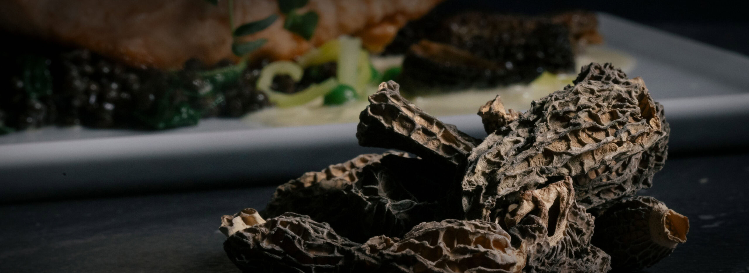 Dried Morel mushrooms in front of an ingredients platter.