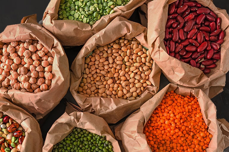 Legumes in paper bags showcasing a variety of beans and peas in bright colors