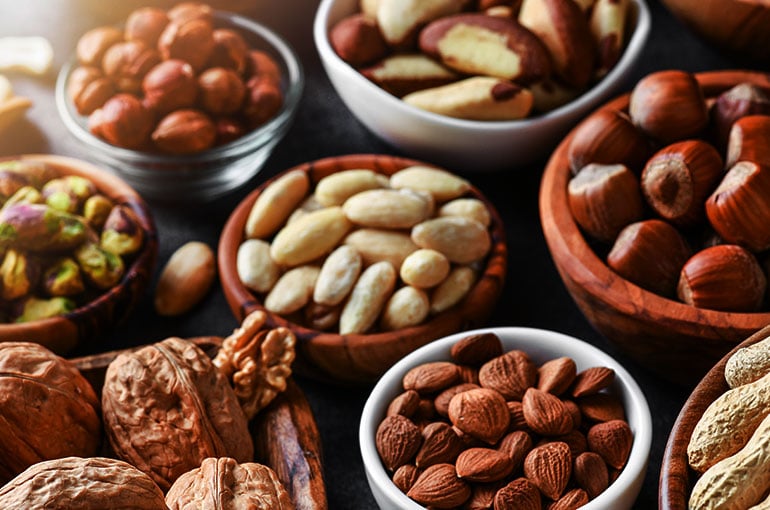 Small bowls holding nut and seed varieties in and out of the shell.