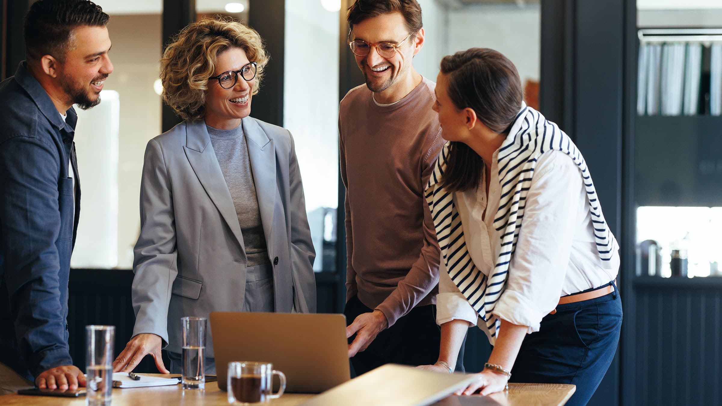 a group of people collaborating in front of a laptop