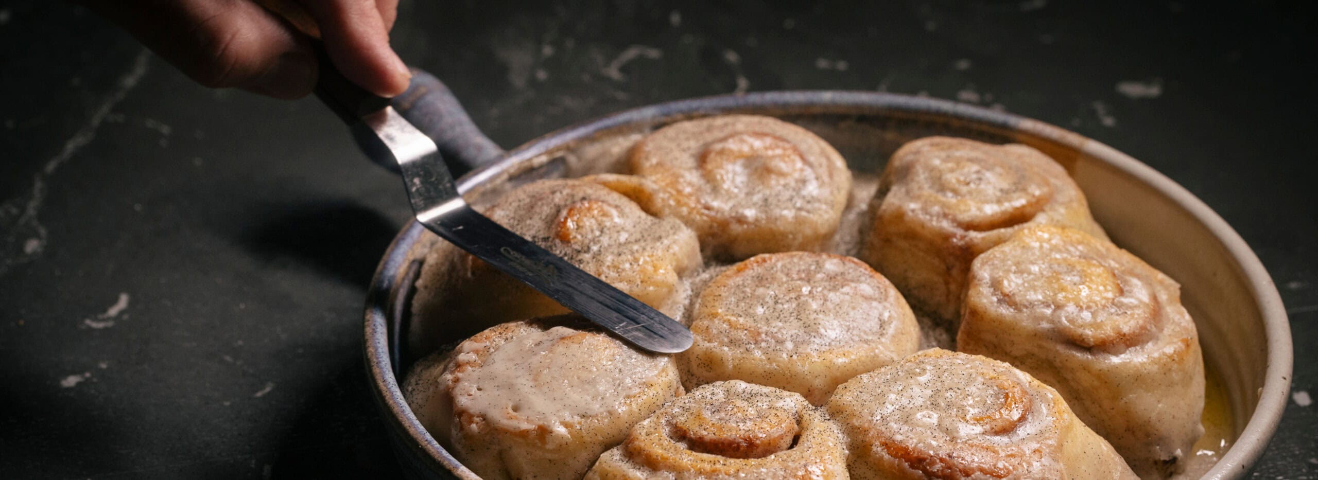 Sweet rolls in a pan with creamy sauce.