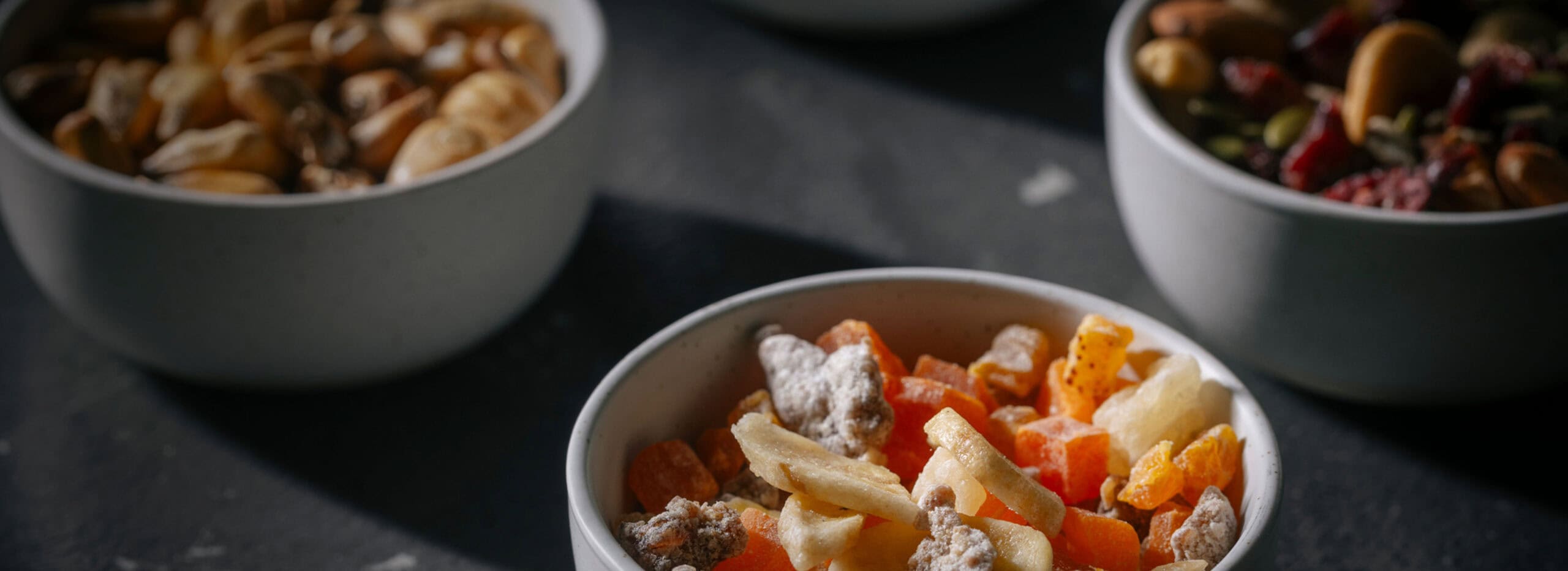 Assortment of snacks in small white bowls.