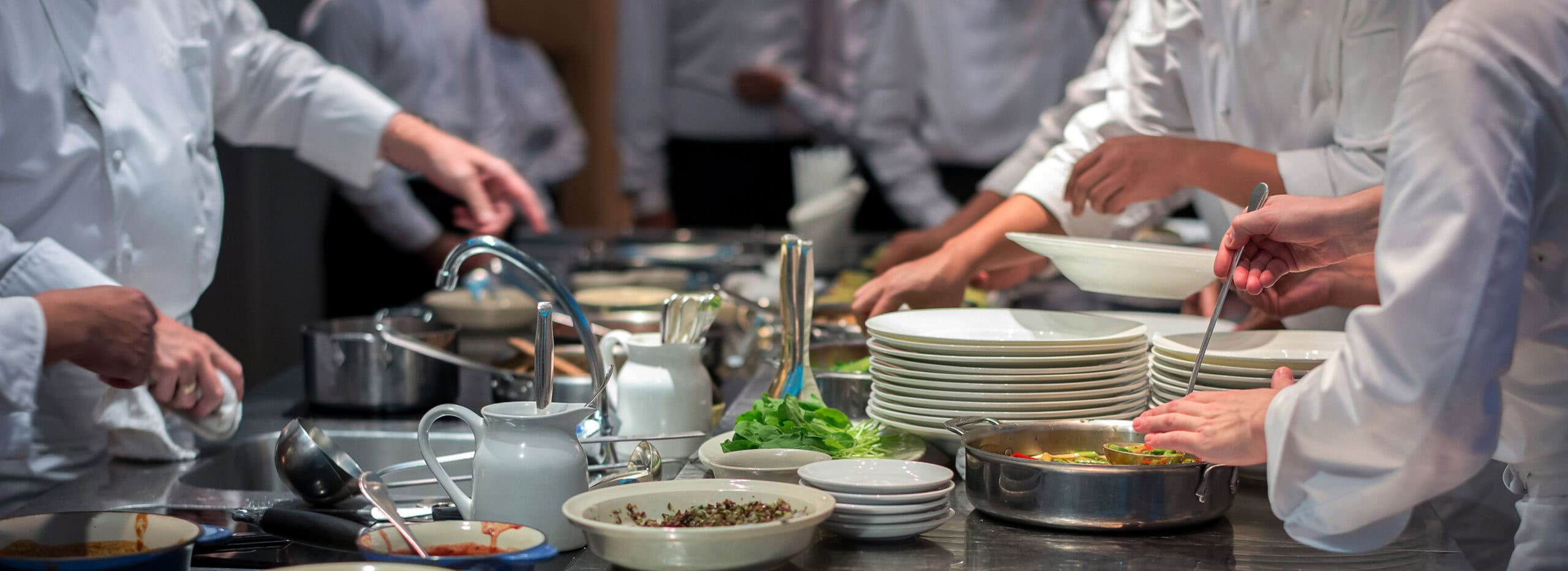 a group of chefs working alongside each other