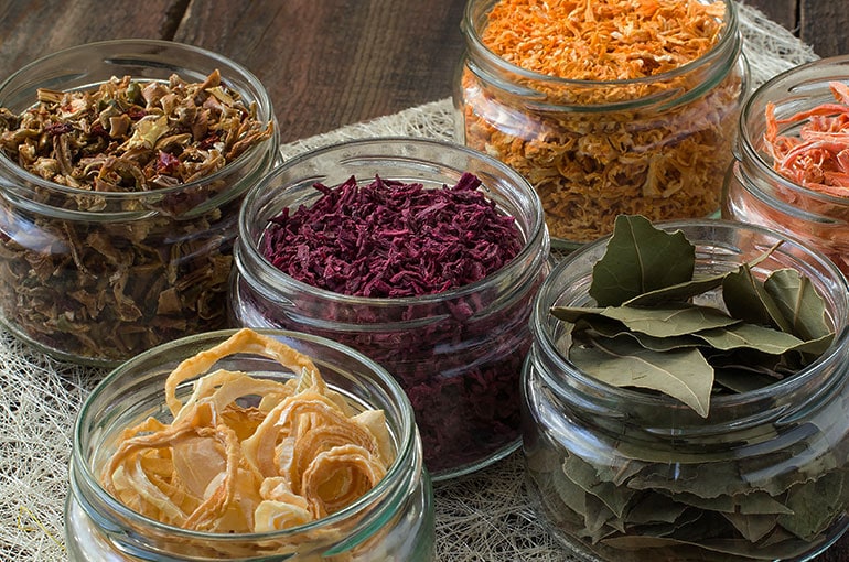 glass jars filled with a variety of dried vegetables